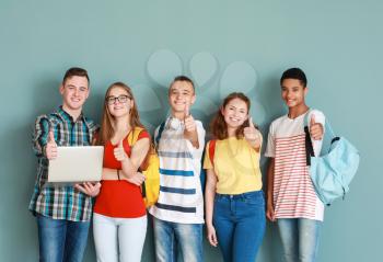 Group of teenagers showing thumb-up on color background�