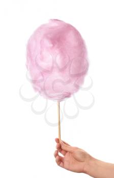 Female hand with tasty cotton candy on white background�