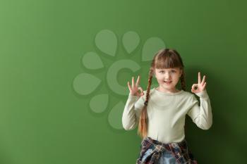 Cute deaf mute girl using sign language on color background�