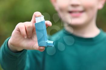 Boy with inhaler outdoors on spring day, closeup�