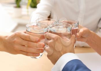 People drinking water in office, closeup�