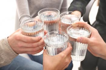 Group of people drinking water indoors, closeup�