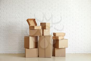 Cardboard boxes near white brick wall�