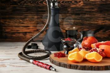 Hookah with tobacco and fresh fruits on table�