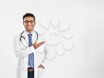 Handsome male doctor showing something on white background�