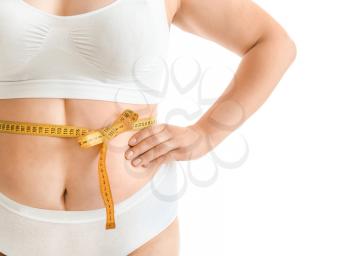 Plus size woman with measuring tape on white background. Concept of weight loss�