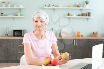 Mature woman after chemotherapy in kitchen at home�