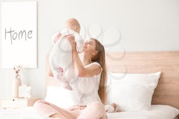 Happy mother with cute little baby at home�