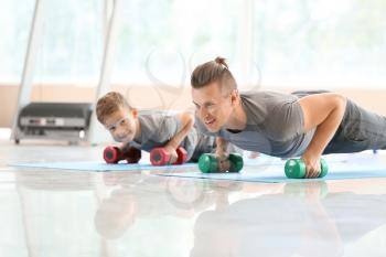 Father and son training together in gym�