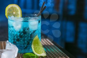 Glass of Blue Lagoon cocktail on table in bar�
