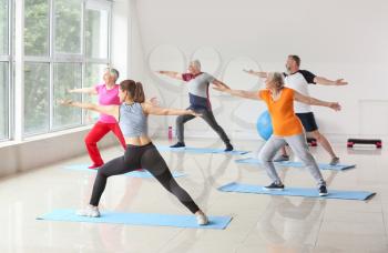 Elderly people training with instructor in gym�