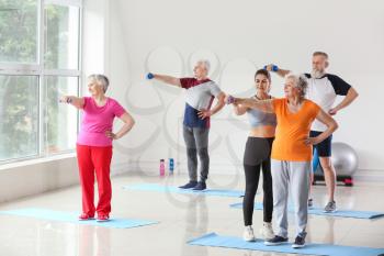 Elderly people training with instructor in gym�