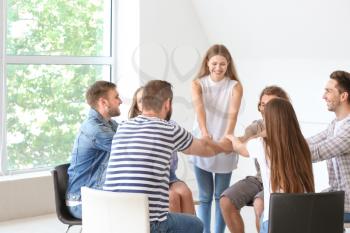 Young people holding hands together at group therapy session�