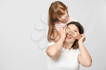 Portrait of happy mother and daughter on light background�