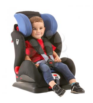 Little boy buckled in car seat on white background�