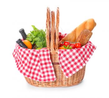 Wicker basket with tasty food and drink for picnic on white background�