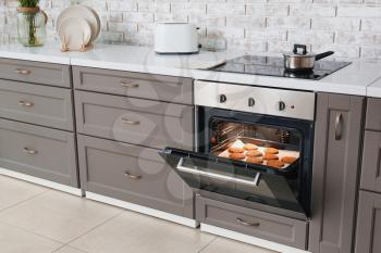 Open oven with tasty homemade cookies in kitchen�