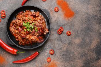 Frying pan with tasty chili con carne on grey background�
