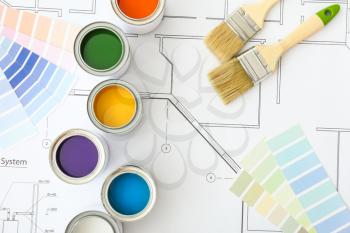 Cans of paint with brushes, palette samples and house plan�