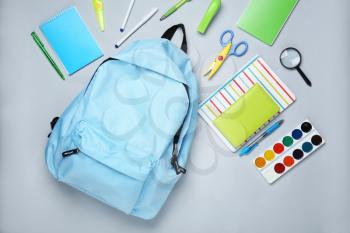 School backpack and stationery on light background�