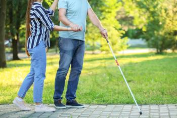 Blind mature man with daughter walking in park�