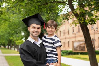 Man with his little son on graduation day�