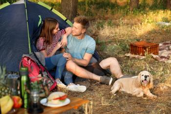 Young couple with cute dog spending weekend in forest�