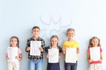 Children with answer sheets for school test on light color background�