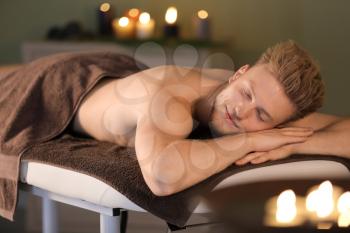 Handsome young man relaxing in spa salon�