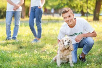 Teenage volunteer with cute dog outdoors�