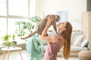 Beautiful woman with cute cat at home�