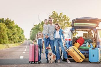 Happy family with luggage near car outdoors�