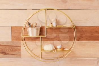Stylish shelf with bath supplies on wooden wall�