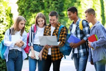 Group of students with laptop outdoors�
