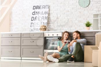 Happy young couple drinking wine after moving into new house�