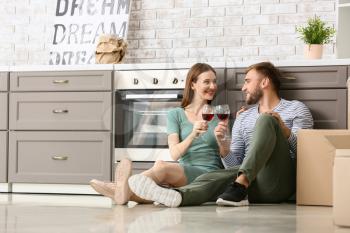 Happy young couple drinking wine after moving into new house�