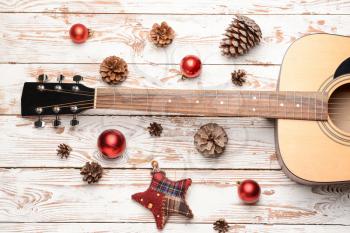 Guitar and Christmas decor on wooden background�