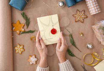 Female hands with creative Christmas card on paper background�