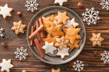Plate with tasty Christmas cookies on wooden table�