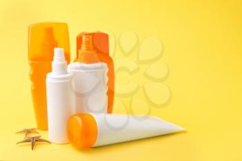 Different sun protection creams on color background�