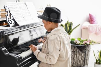 Little African-American boy playing grand piano at the concert�