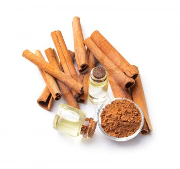 Aromatic cinnamon sticks and essential oil on white background�