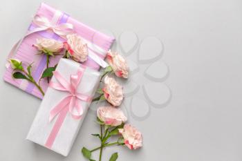 Gift boxes and beautiful flowers on light background�