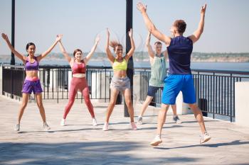 Group of young sporty people training together outdoors�