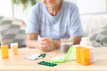 Elderly woman with medicines at home�