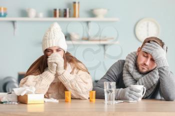 Sick couple sitting at kitchen table�