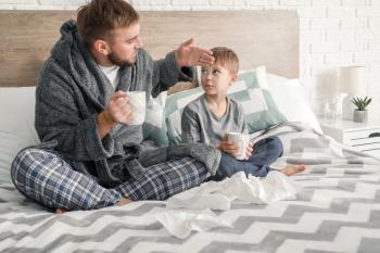 Father and his little son ill with flu at home�