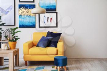 Stylish interior of living room with yellow armchair�