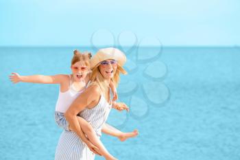 Portrait of happy mother and daughter on sea beach�
