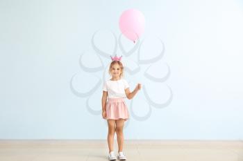 Little girl with balloon near color wall�